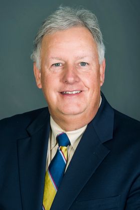 photo of man in blue suit jacket, gold, blue tie