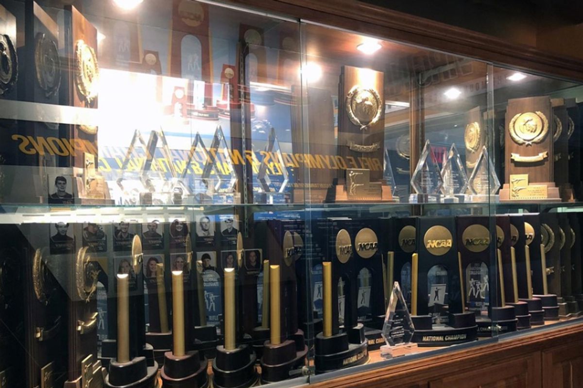 WVU rifle team trophies and awards in display case behind glass