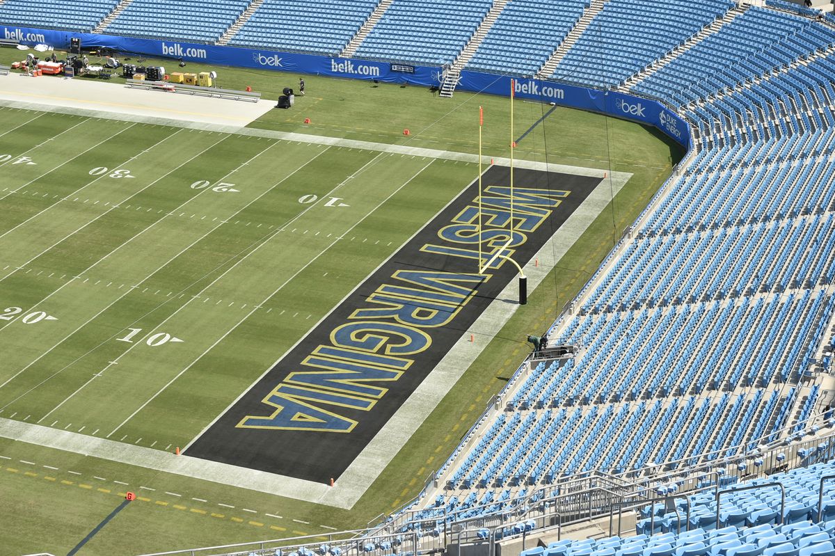 A photograph showing the football field at Bank of America stadium in Charlotte, North Carolina. All the seating is University of North Carolina Tarheel blue and the end zone is painted with the words West Virginia. 