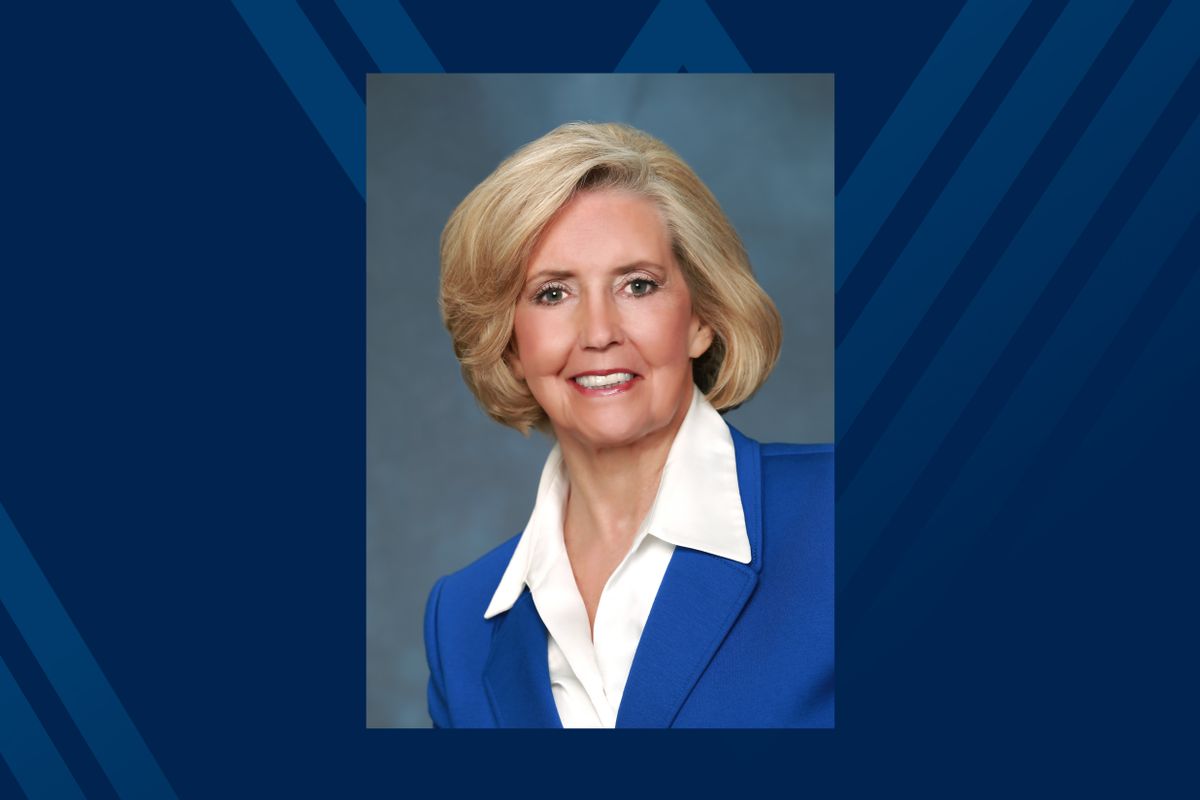 Photo of white woman in blue suit on blue background