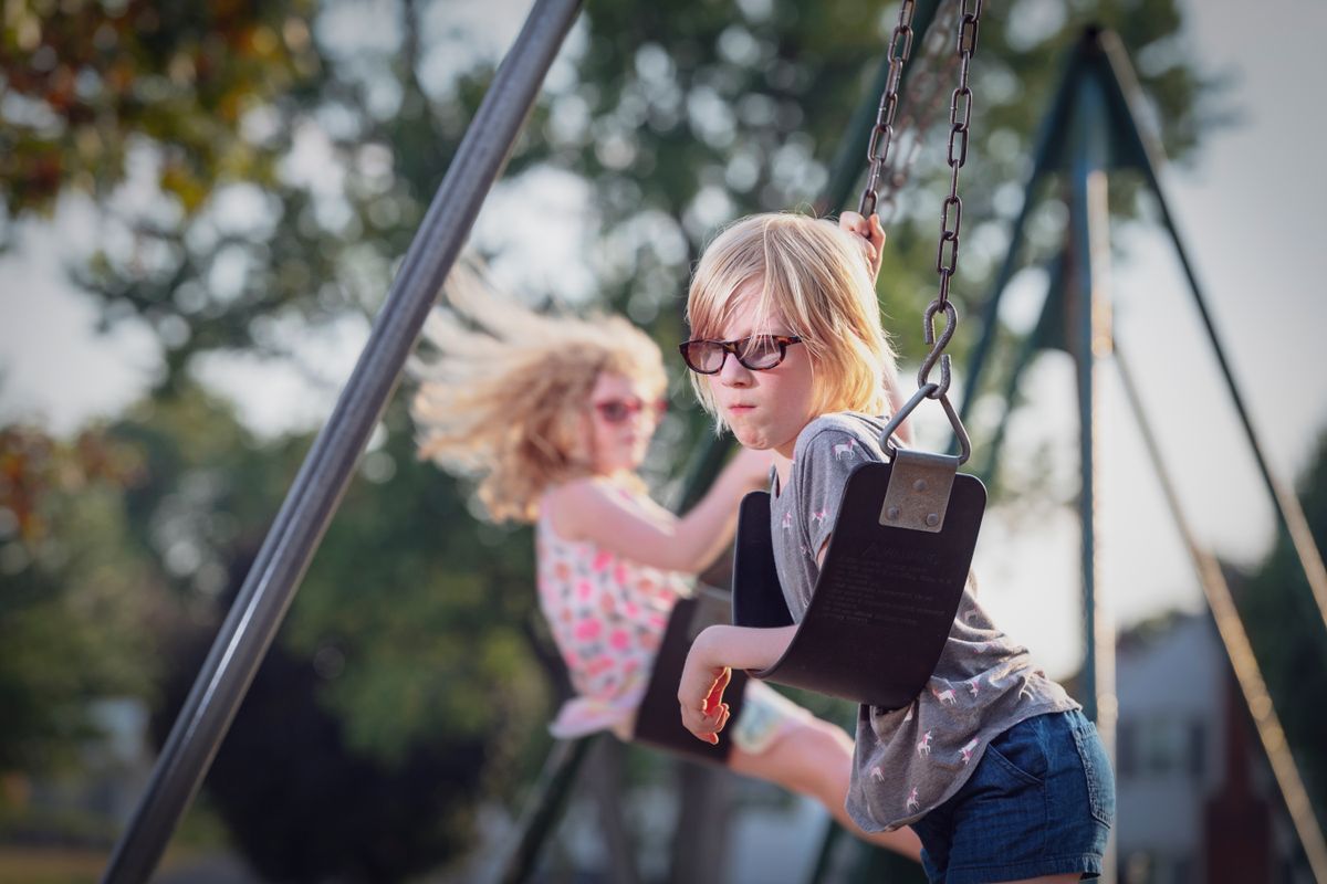 photo of two girls on swings