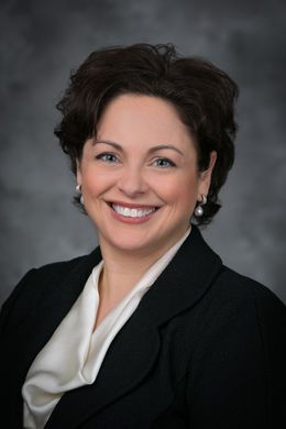 headshot of smiling white woman in suit