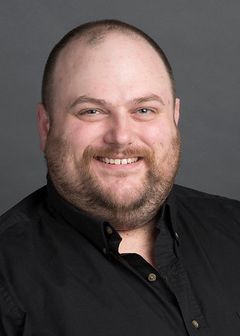 smiling man in black shirt, beard