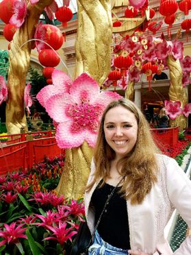 smiling woman in front of large flower display