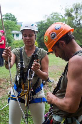A man and woman don caving gear