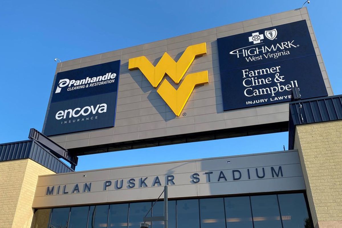 advertisements on large sign with flying WV in the center