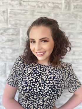 Scholarship recipient Cassandra Stewart is pictured. She had shoulder length brown, curly hair pulled away from her face, and she's wearing a short sleeve black and off white top. 