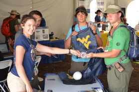 A scout receiving a patch and a WVU bag at Jambo in 2013.  