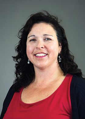 Headshot of WVU Extension agent Lauren Weatherford. Weatherford is pictured wearing a red top and black sweater. She has long, curly dark hair. 