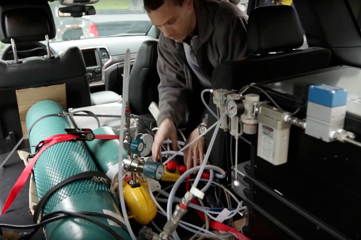 Marc Besch installs emissions testing equipment in a vehicle at the WVU CAFEE lab.