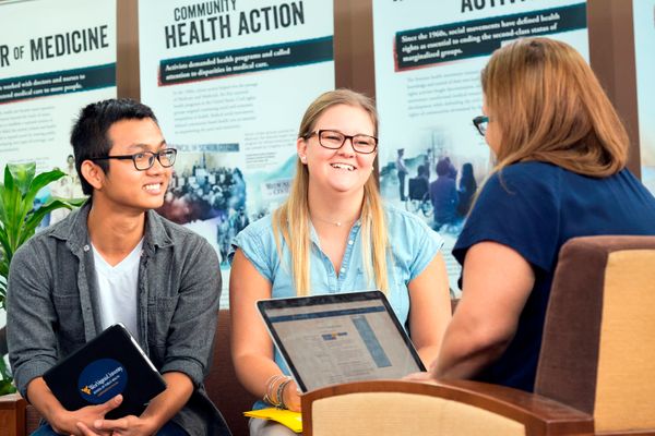 Two School of Public Health students talk with an advisor.