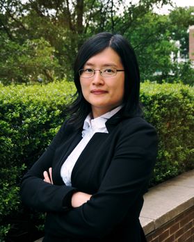 photo of woman in dark business suit, white blouse, glasses