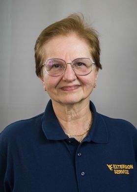 Head shot of smiling older white woman in glasses and WVU Extension Service polo