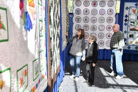 photo of people looking at hanging quilts