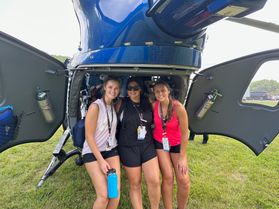 Three WVU School of Nursing student volunteers sit inside an air ambulance helicopter for a photograph. 