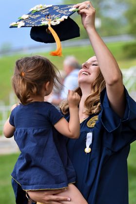 Graduate Paxton Moore smiles as she plays with her niece Aurora Bane following the School of Nursing commencement at the Creative Arts Center Saturday, May 12, 2018.