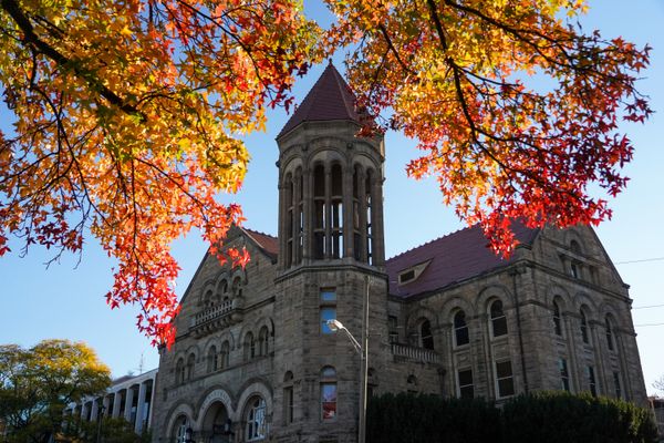 Stewart Hall is shown against blue sky with fall leaves in the top of the photo.