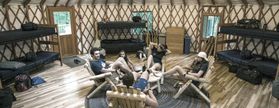 People sit in the commons area of a yurt