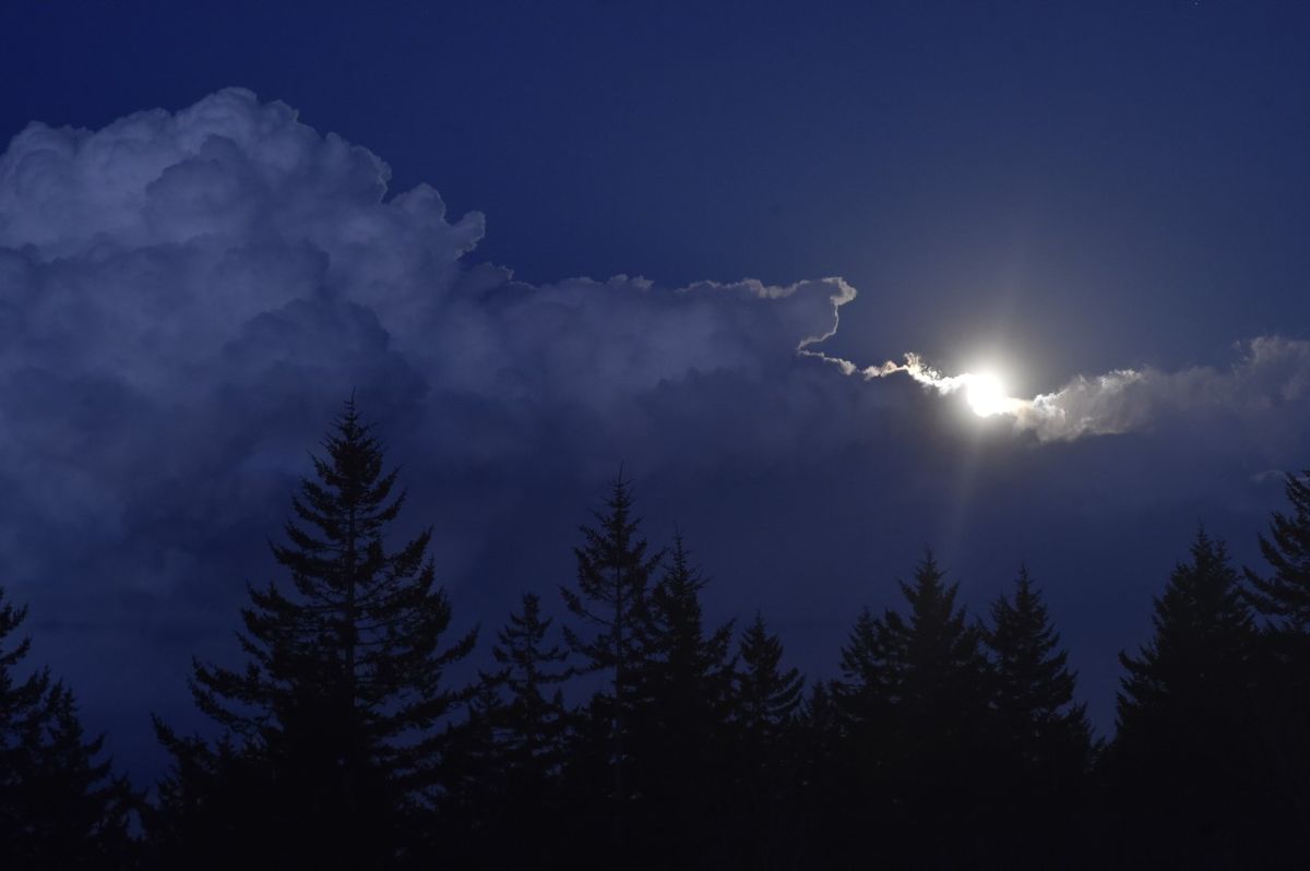 Full moon obscured by clouds.