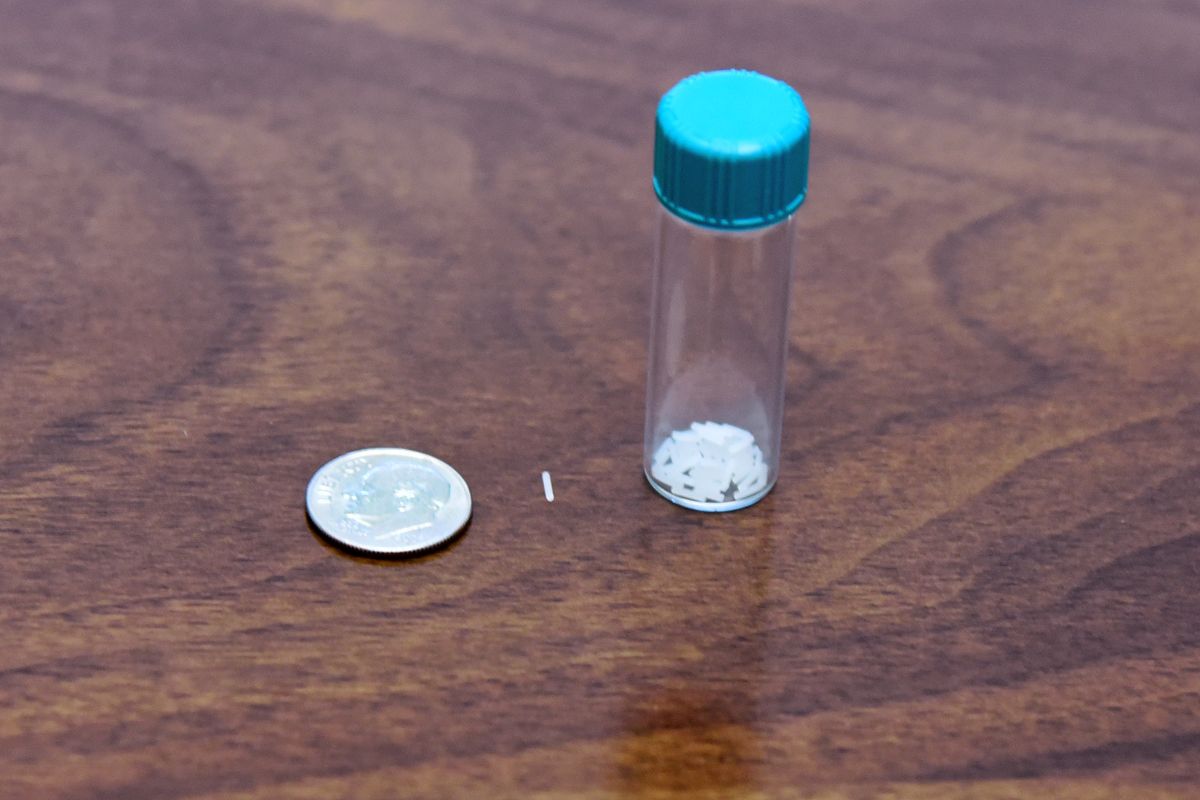 A tube with a white substance and a silver disk the size of a dime