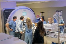 several people stand around an MRI machine