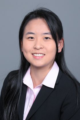 Headshot of WVU Bucklew Scholar Amy Lu. She is pictured against a gray background and is wearing a black jacket with a pink dress shirt. She has long black hair and is of Asian decent. 