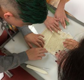 students work with a piece of old paper
