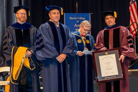 Jack Furst receives an HDR from WVU President Gordon Gee (L) and Dean Javier Reyes (L) at the 2018 Eberly College of Arts and Science and the John Chambers College of Business and Economics Commencement. 